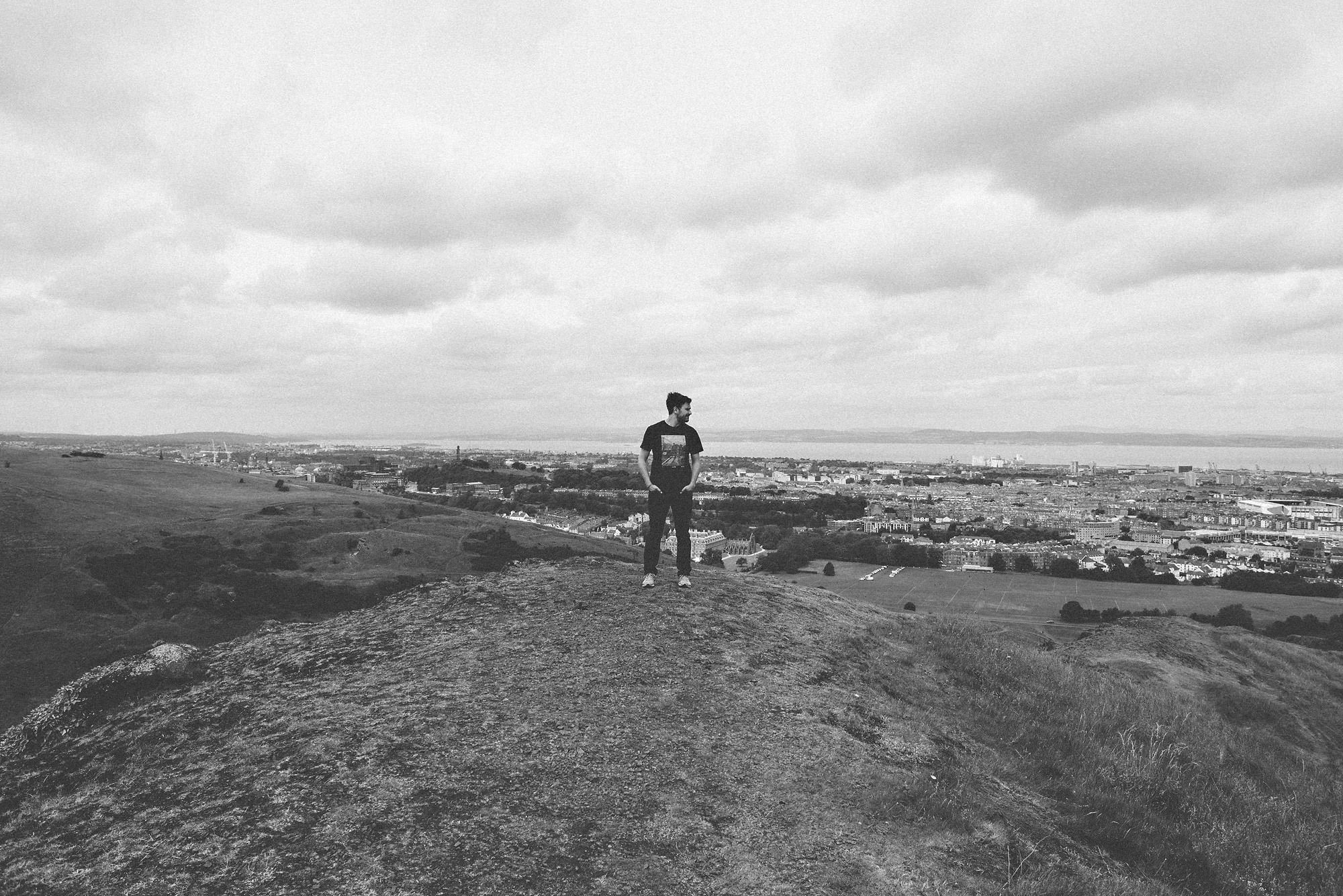 Callum Pinkney Photographer posing at Arthur's Seat in black and white