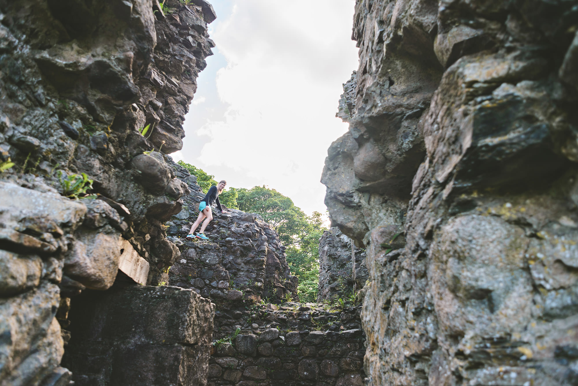 Woman standing a top crumbles castle rocks