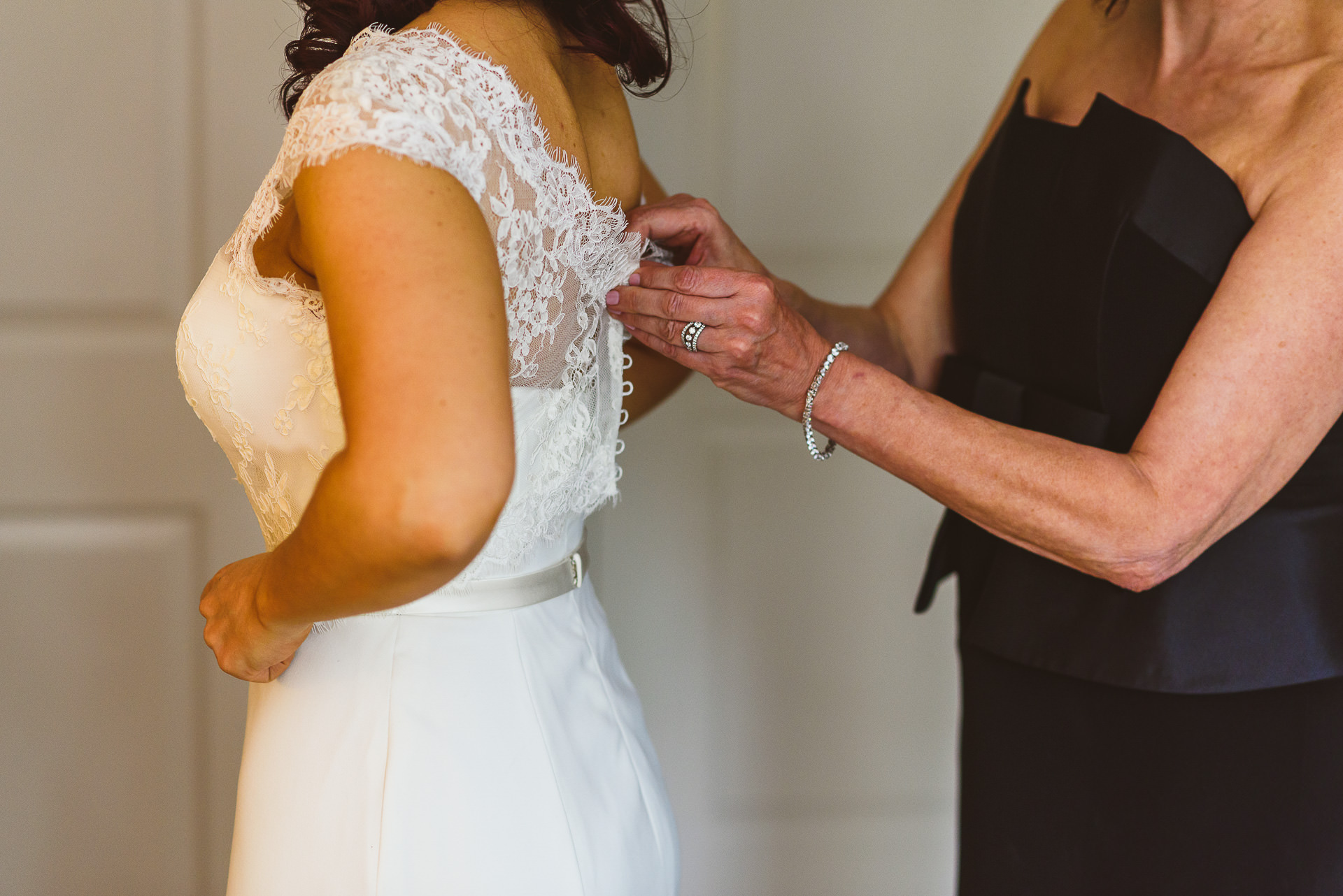 Mom helping bride with dress