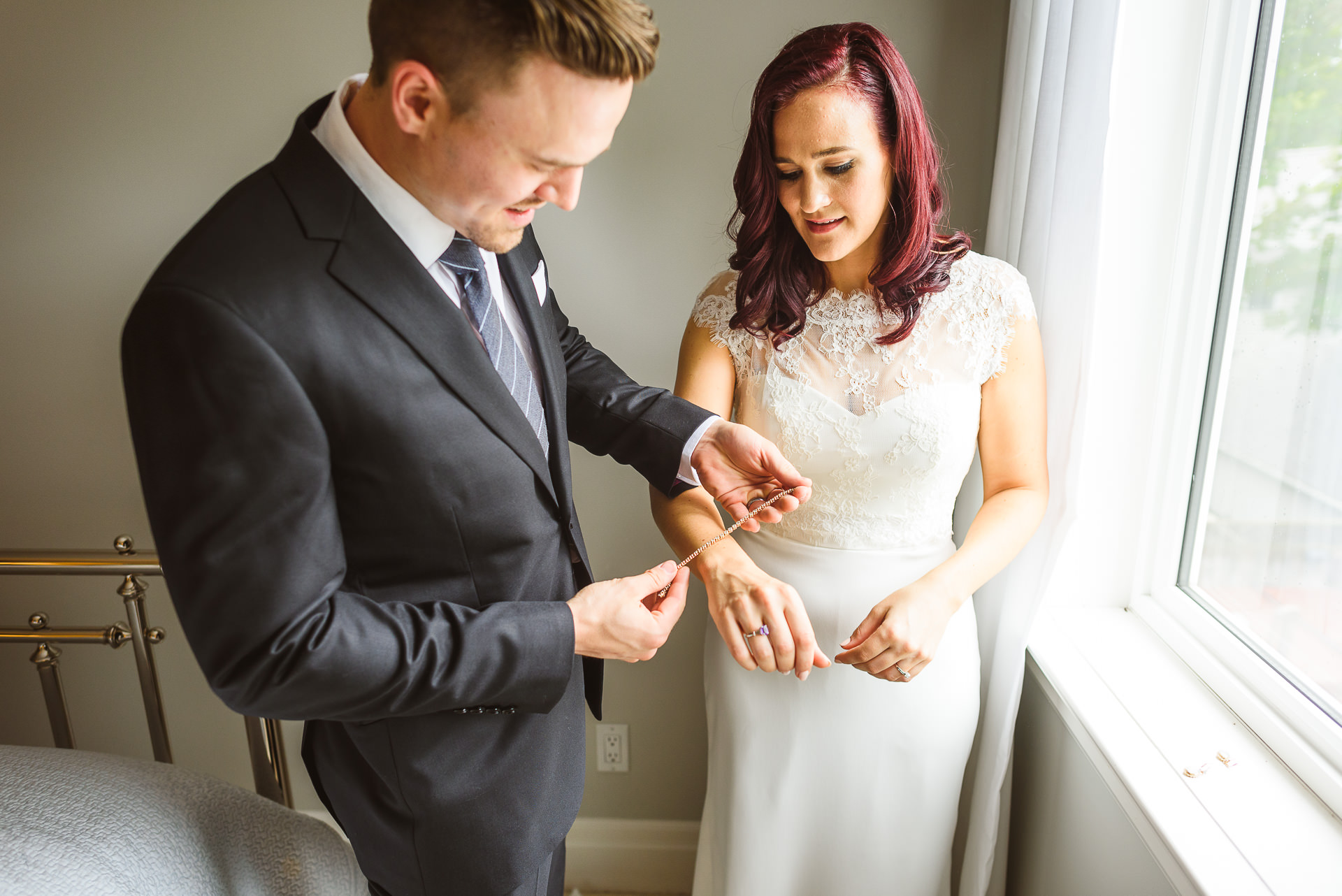 Brother putting bracelet on bride