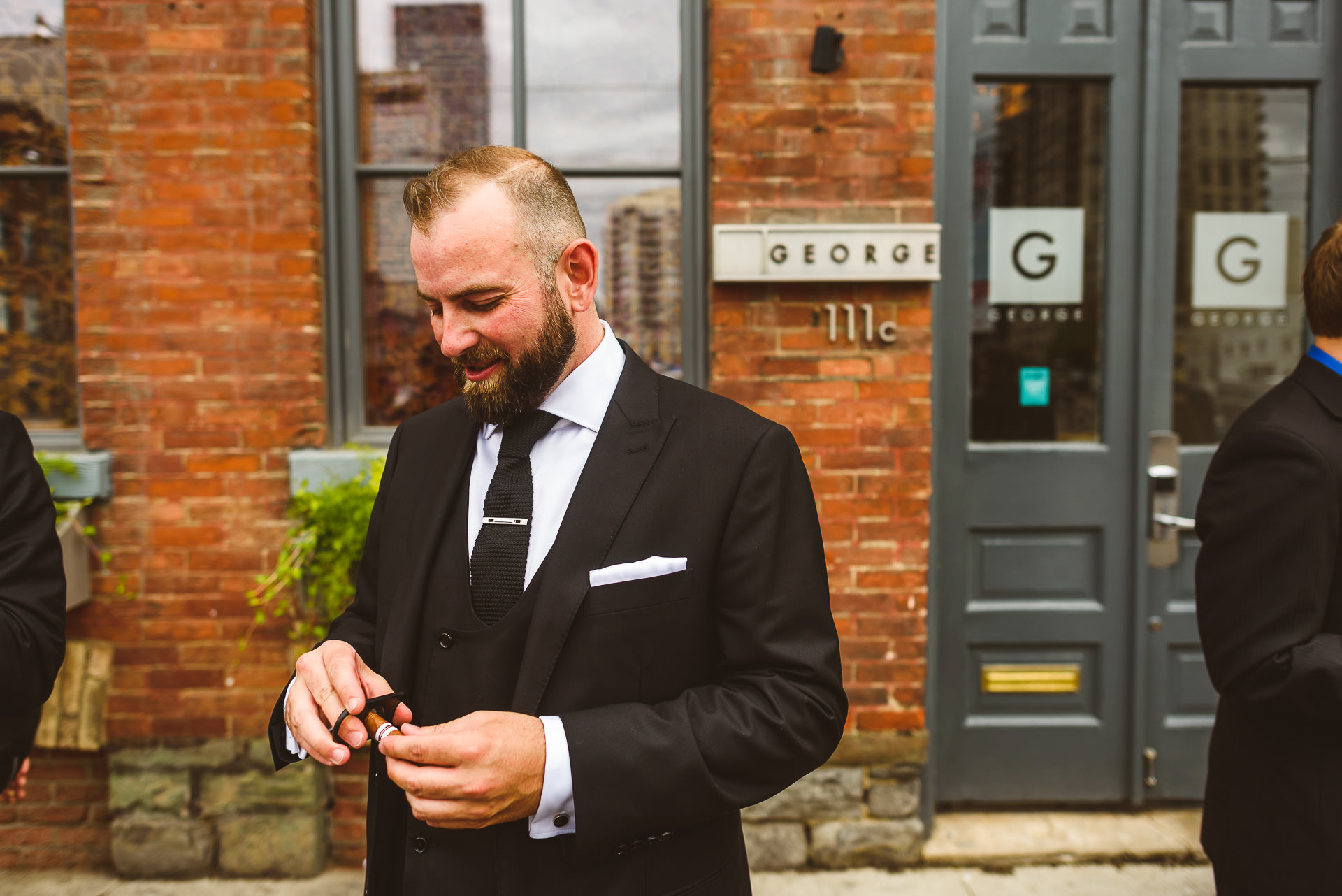 Groom having cigar outside The Ivy Hotel wedding