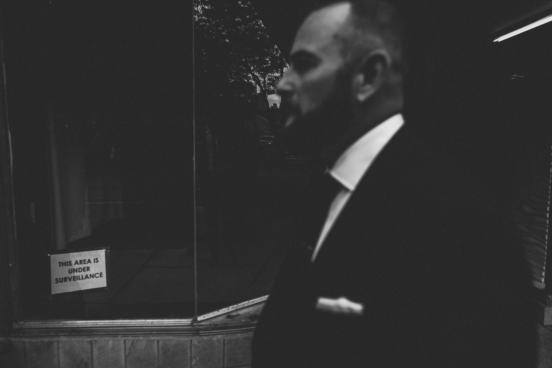 portrait of groom with sign in Toronto wedding queen st w